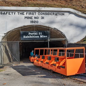A group stands confidently at a mine entrance, highlighting safety and teamwork, dated 1920.