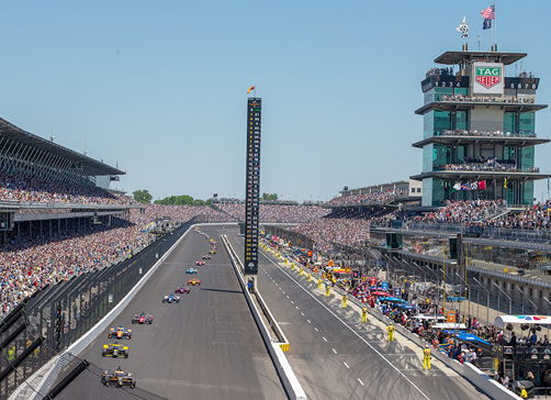 Vibrant motorsport event with speeding cars, excited crowd, and a professional backdrop, capturing the thrill and energy.
