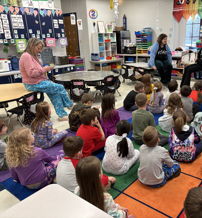 Classroom scene with children in playful attire and adults engaging them, fostering curiosity and a joyful learning environment.