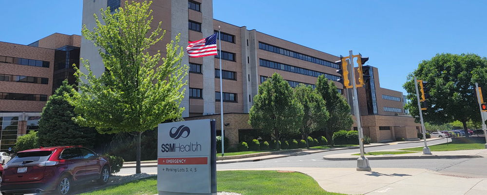 Modern healthcare facility under a clear blue sky, surrounded by greenery, exuding positivity and community care.