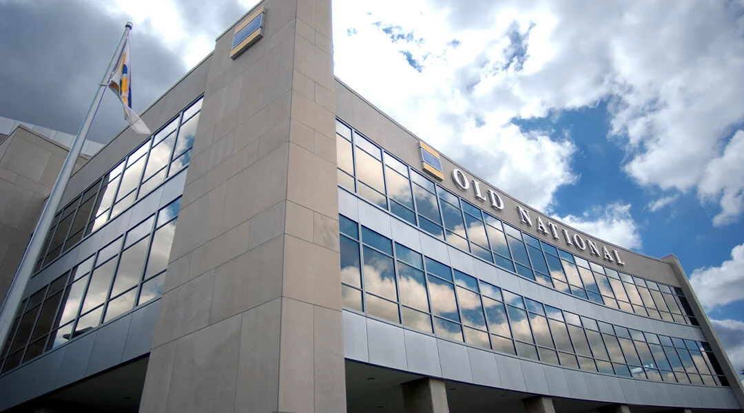 Modern corporate office with glass windows reflecting clouds, conveying professionalism, stability, and optimism.