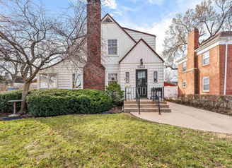 A charming house with white siding and brick, featuring a porch and manicured yard, evokes warmth and nostalgia.
