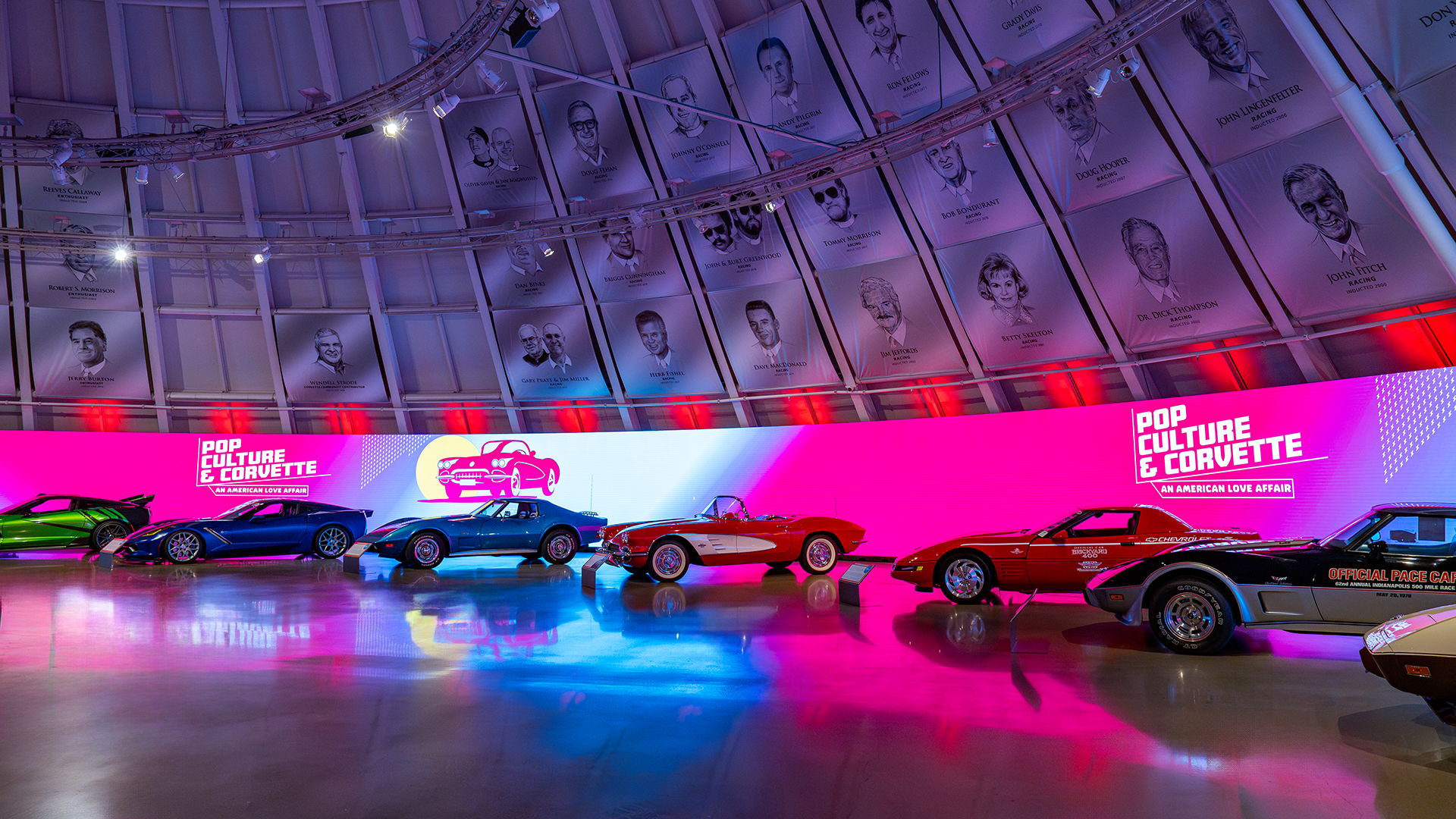 Vibrant exhibition space showcasing vintage Corvettes with dynamic lighting and pop culture graphics, evoking nostalgia and excitement.