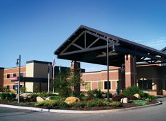 Modern building with a welcoming entrance, sleek design, and landscaped surroundings, evoking warmth and hospitality.