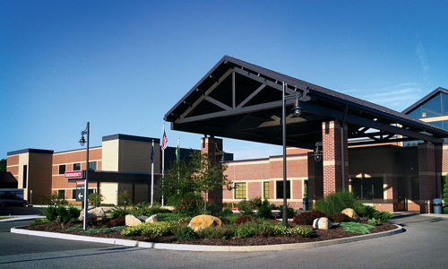 Modern building with a welcoming entrance, sleek design, and landscaped surroundings, evoking warmth and hospitality.