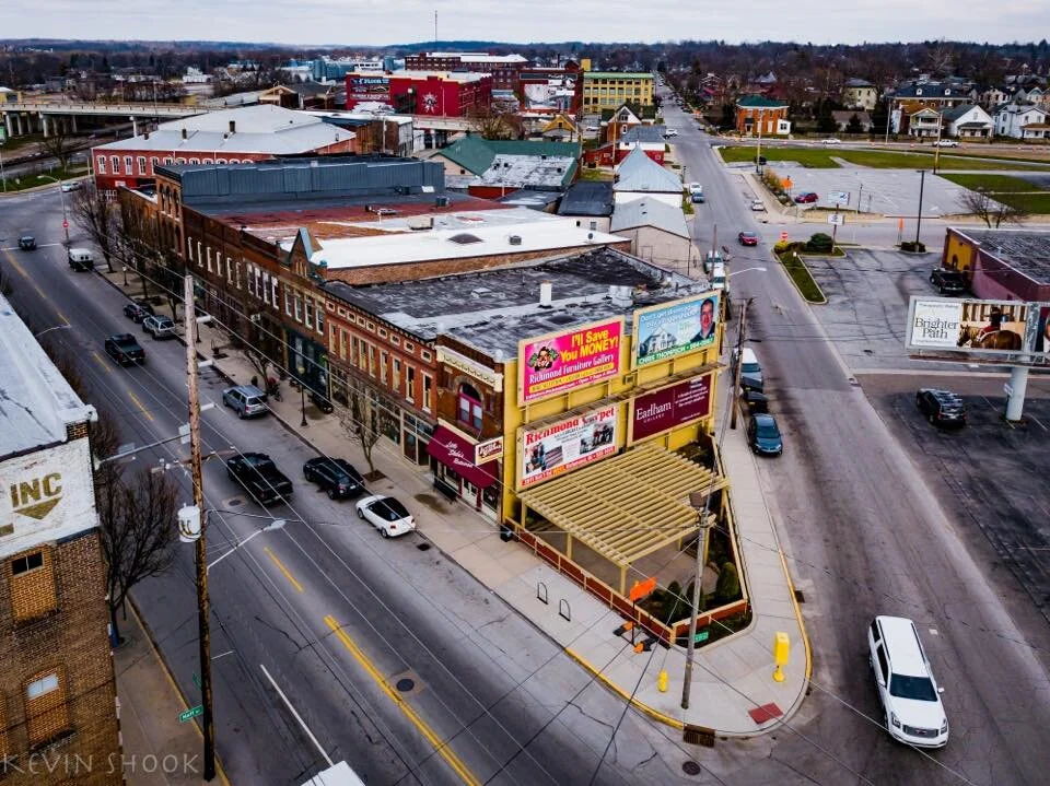 Quaint urban landscape blending older and newer buildings, bustling streets, evoking nostalgia, community, and curiosity.