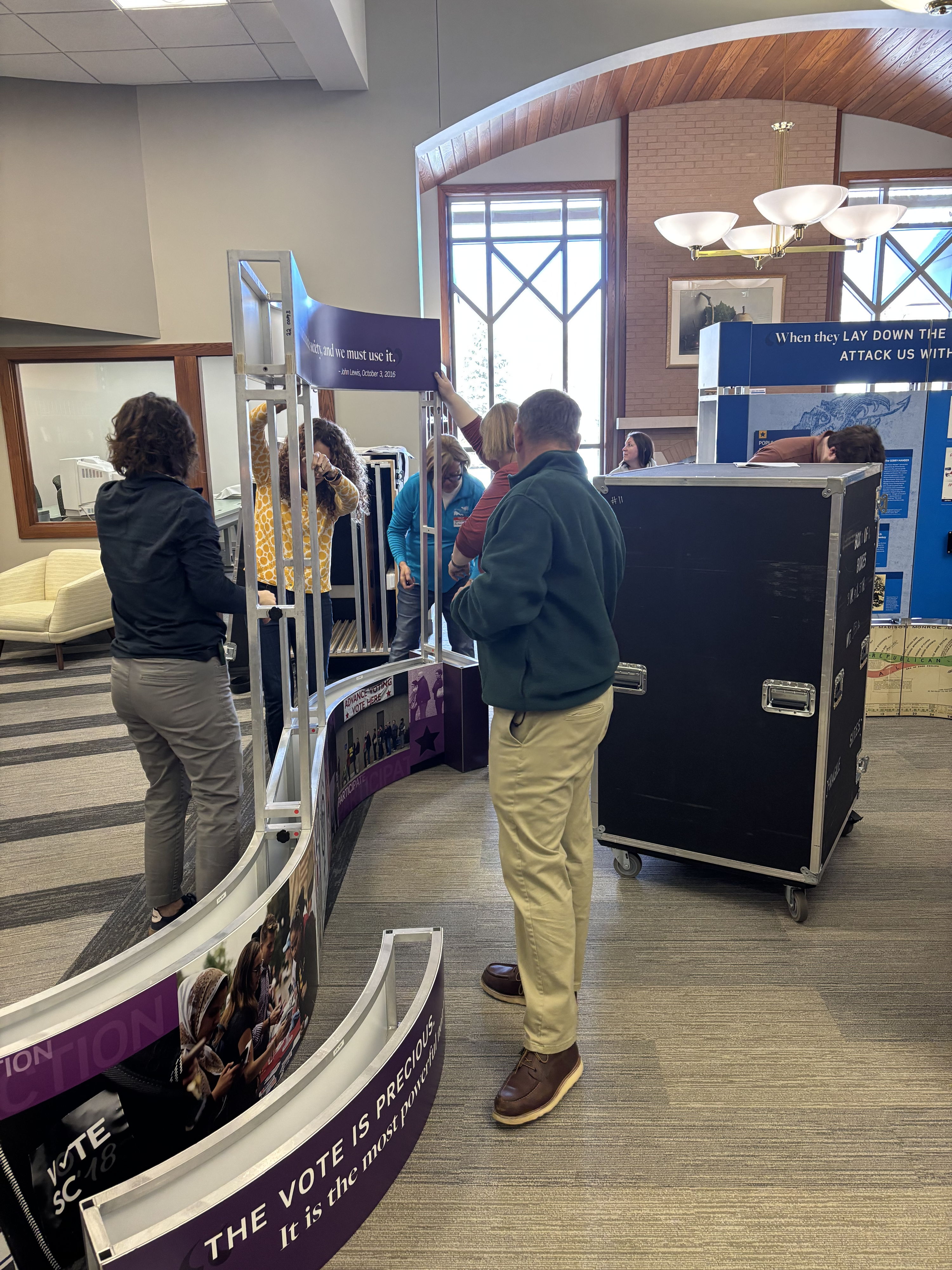 Busy conference scene with professionals networking, engaging by signage and displays, evoking excitement and collaboration.