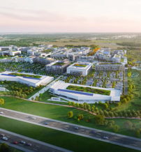Aerial view of a modern urban development with buildings, green spaces, and roads, evoking growth, sustainability, and community.
