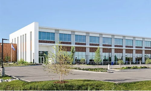 Modern commercial building with large glass windows, lush landscaping, and an inviting atmosphere, conveying professionalism and serenity.