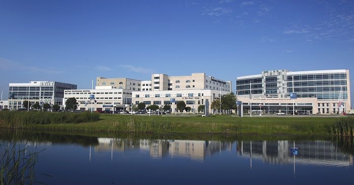 Modern urban scene with white glass buildings, calm water reflection, greenery, and a bright sky conveying harmony and optimism.