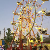 A vibrant Ferris wheel lit up against a dusky sky, evoking joy and excitement in a festive carnival atmosphere.