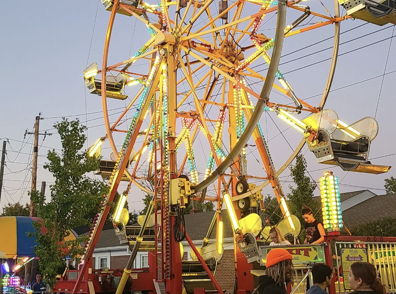 A vibrant Ferris wheel lit up against a dusky sky, evoking joy and excitement in a festive carnival atmosphere.