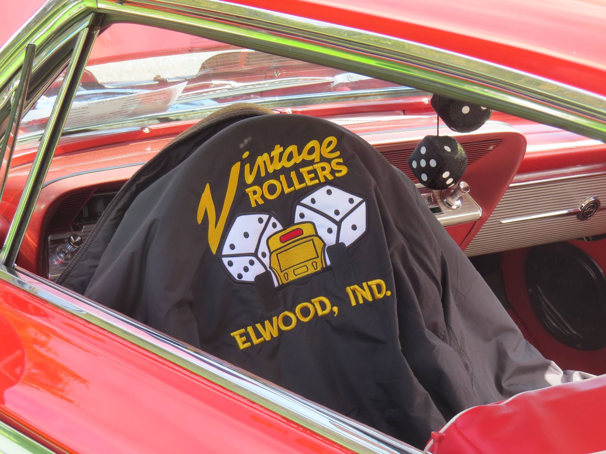 Classic car interior with a black logoed seat, red accents, evoking vintage charm and playful nostalgia for classic car culture.