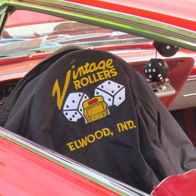 Classic car interior with a black logoed seat, red accents, evoking vintage charm and playful nostalgia for classic car culture.