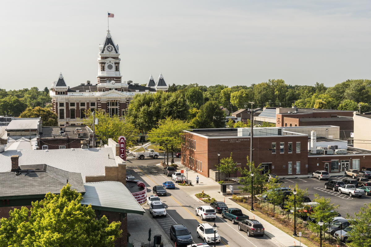 Charming town with a historic clock tower, vibrant community, greenery, and inviting streets that evoke nostalgia and comfort.