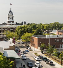 Charming town with a historic clock tower, vibrant community, greenery, and inviting streets that evoke nostalgia and comfort.