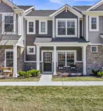 Contemporary townhouses with stone and siding, inviting porches, vibrant red chair, and a welcoming neighborhood feel.