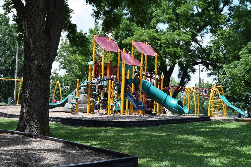 Vibrant playground with colorful equipment in a lush, green setting, evoking joy and nostalgia of carefree childhood days.