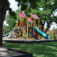 Vibrant playground with colorful equipment in a lush, green setting, evoking joy and nostalgia of carefree childhood days.