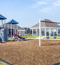 Brightly colored playground with slides, climbing areas, and a gazebo, set against a blue sky, evoking joyful childhood memories.