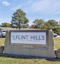 A welcoming care center, "Flint Hills," with a clear sign, lush lawns, and a serene atmosphere, evoking safety and comfort.