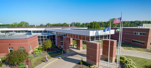 A modern building with flags, lush gardens, and a sunny sky evokes optimism and community warmth.
