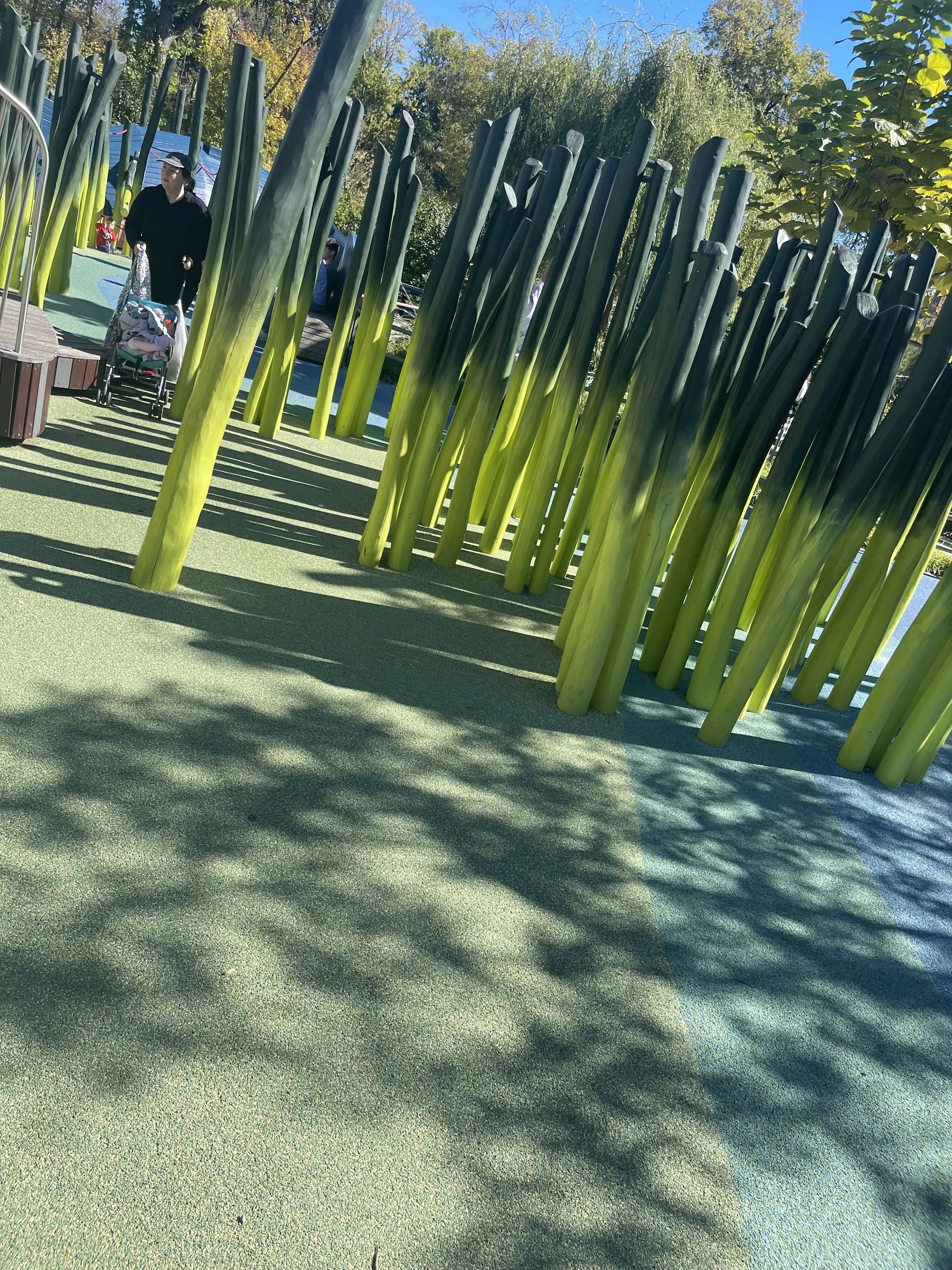 Colorful playground with tall structures on textured ground, sunny day, evoking joy and playful exploration for families.