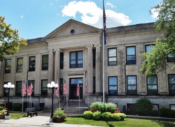 Grand classical building with columns, flags, and landscaped surroundings, evoking stability, tradition, and community pride.