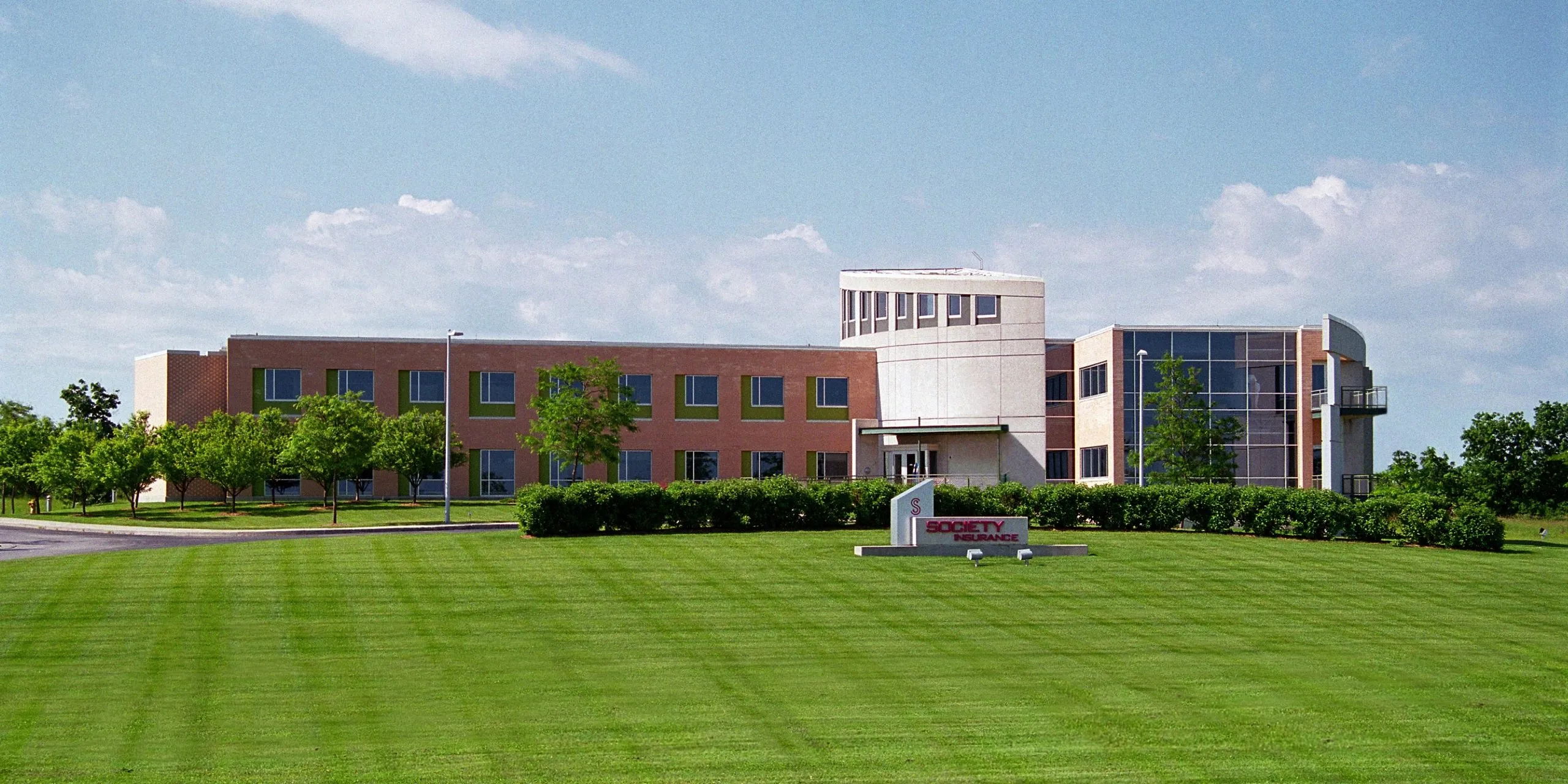 Modern building with brick and glass in a green landscape, evoking tranquility, professionalism, and positivity.