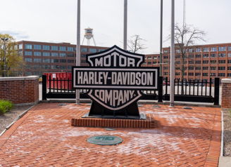 Harley-Davidson logo outside, set against brick and industrial backdrop, evokes nostalgia, pride, and motorcycle culture.