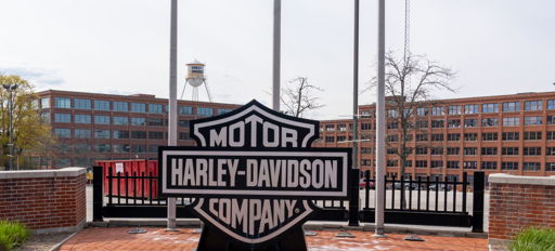 Harley-Davidson logo outside, set against brick and industrial backdrop, evokes nostalgia, pride, and motorcycle culture.