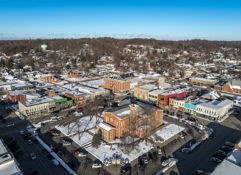 Aerial view of a snow-covered small town, featuring colorful buildings and serene winter landscapes, evoking charm and nostalgia.