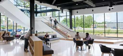 Modern open space with large windows, minimalistic furniture, and diverse groups engaged in conversation, conveying collaboration.
