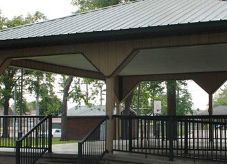 A tranquil gazebo in a park, surrounded by greenery, invites relaxation and social gatherings in a serene outdoor setting.