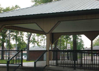 A tranquil gazebo in a park, surrounded by greenery, invites relaxation and social gatherings in a serene outdoor setting.
