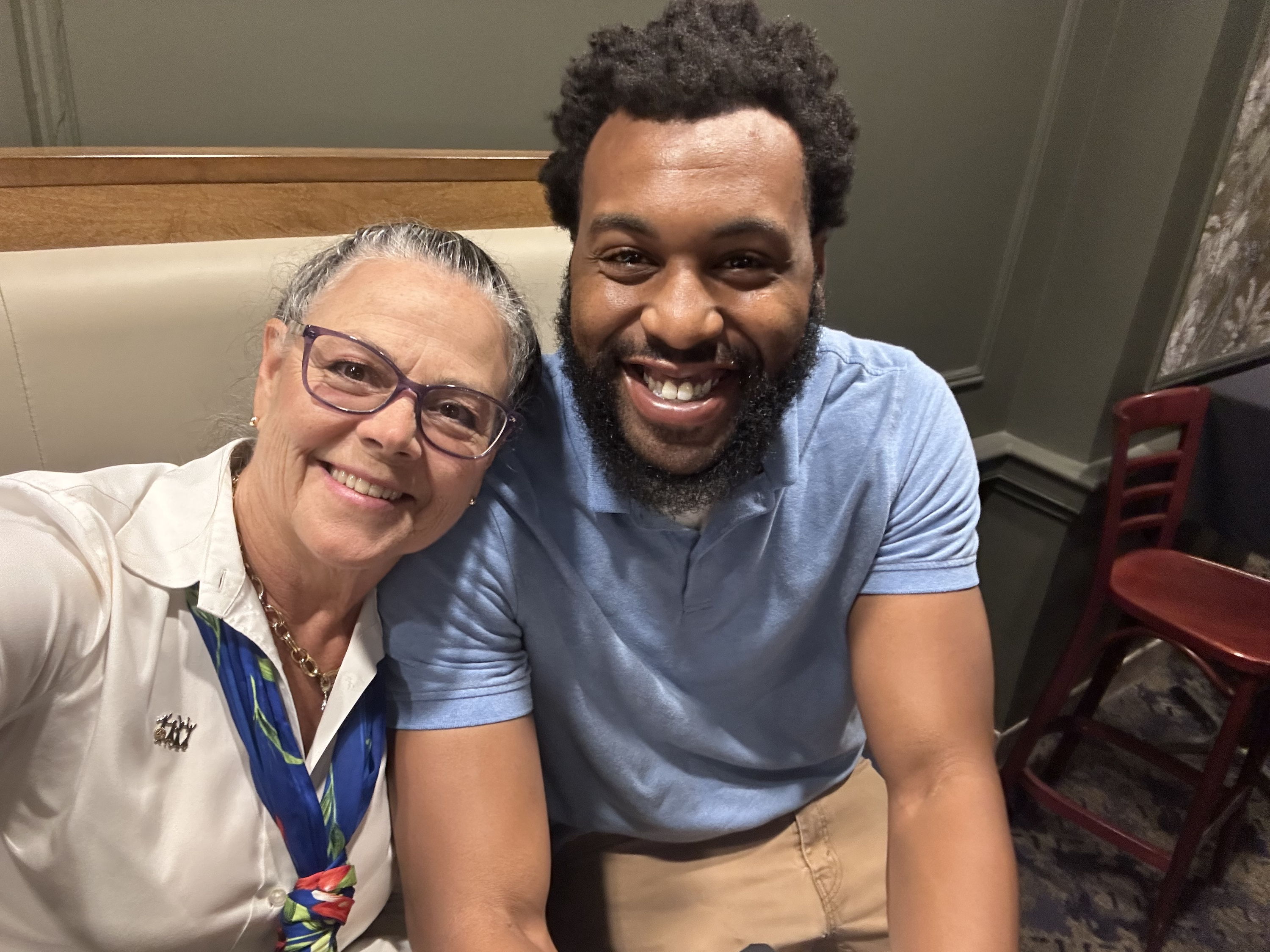 Two smiling individuals in a casual setting convey happiness and camaraderie, suggesting a moment of joy and connection.