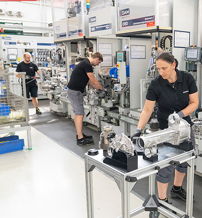 Image of a busy, organized manufacturing setting with focused workers assembling machinery, conveying teamwork and productivity.