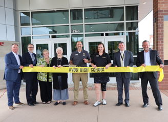 Group at Avon High School ribbon-cutting ceremony, showcasing joy and community pride in a bright, modern setting.