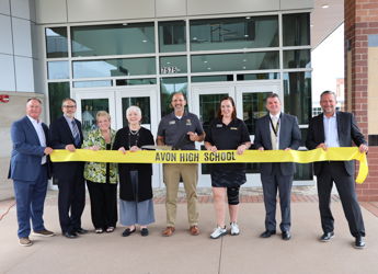Group at Avon High School ribbon-cutting ceremony, showcasing joy and community pride in a bright, modern setting.