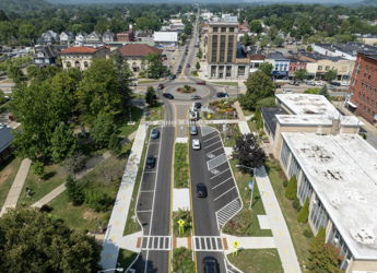 A serene small town view with diverse architecture, greenery, and distant hills, evoking tranquility and a sense of community.