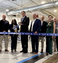 Ribbon-cutting ceremony with formal attendees celebrating a new beginning, exuding excitement and teamwork.