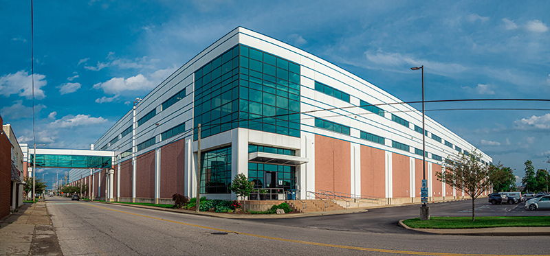 Modern commercial building with glass panels and brick, exuding professionalism under a clear blue sky.
