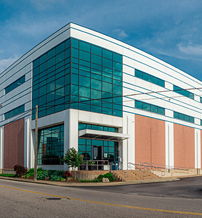 Modern commercial building with glass panels and brick, exuding professionalism under a clear blue sky.