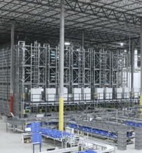 Spacious industrial warehouse with organized shelving, blue containers, and a focus on efficiency and productivity.