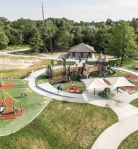 A vibrant playground in a green park with play structures, children, and adults enjoying the joyful, communal atmosphere.