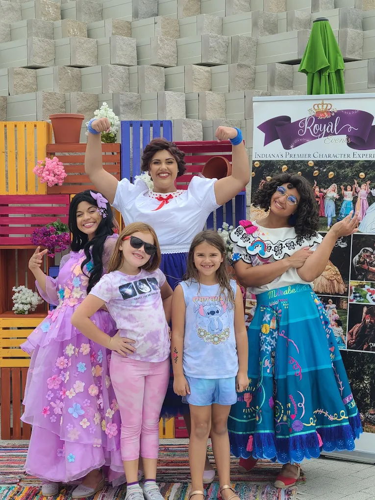 Cheerful group in vibrant costumes and casual wear, creating a joyful, festive atmosphere for a children's-themed event.