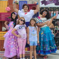 Cheerful group in vibrant costumes and casual wear, creating a joyful, festive atmosphere for a children's-themed event.
