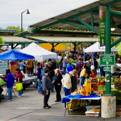 A vibrant market scene with colorful tents, people engaging in activities, creating a lively, joyful atmosphere.