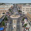 A vibrant street scene during a parade, filled with crowds, flags, and a festive atmosphere, evoking joy and community spirit.