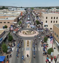 A vibrant street scene during a parade, filled with crowds, flags, and a festive atmosphere, evoking joy and community spirit.